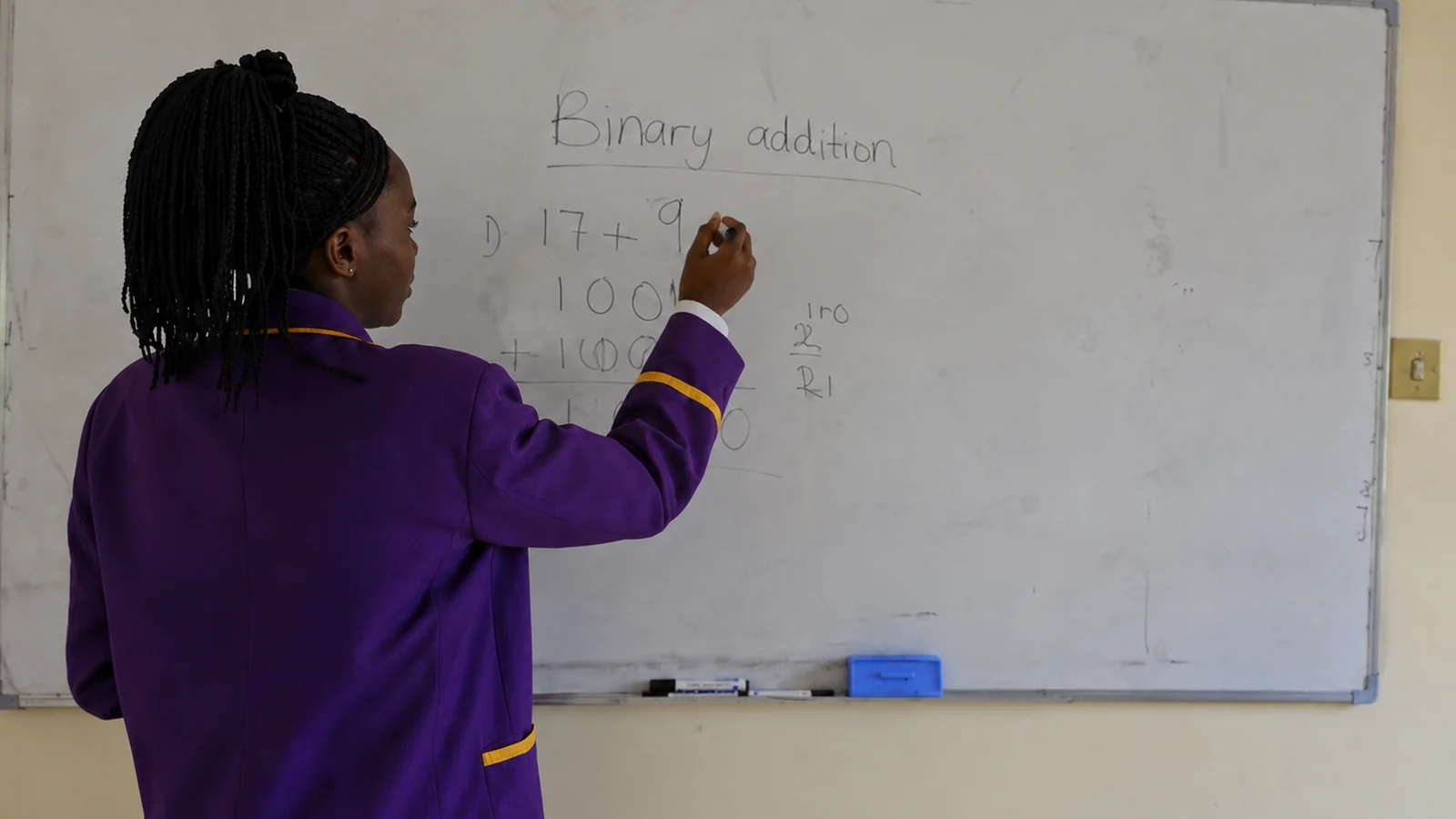A Privian Academy pupil working through binary addition at the whiteboard