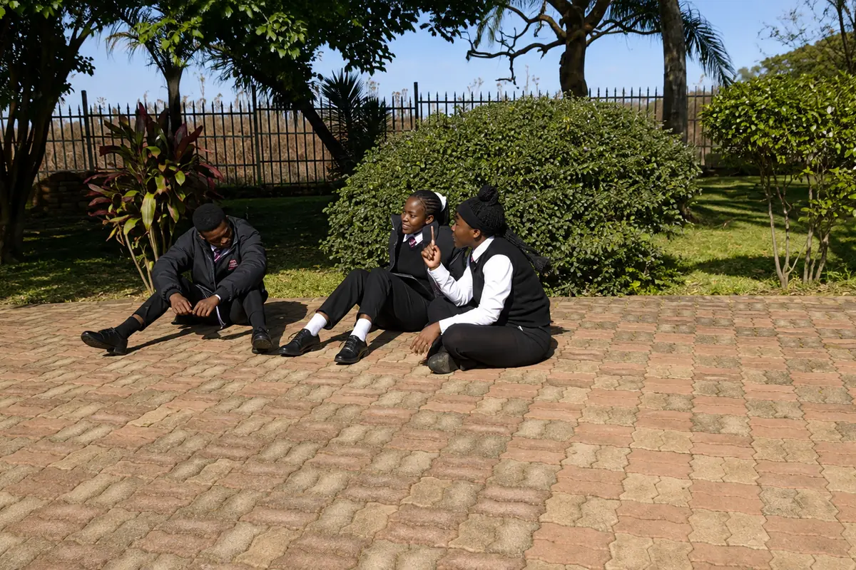 Privian Academy pupils sitting together outside after lessons